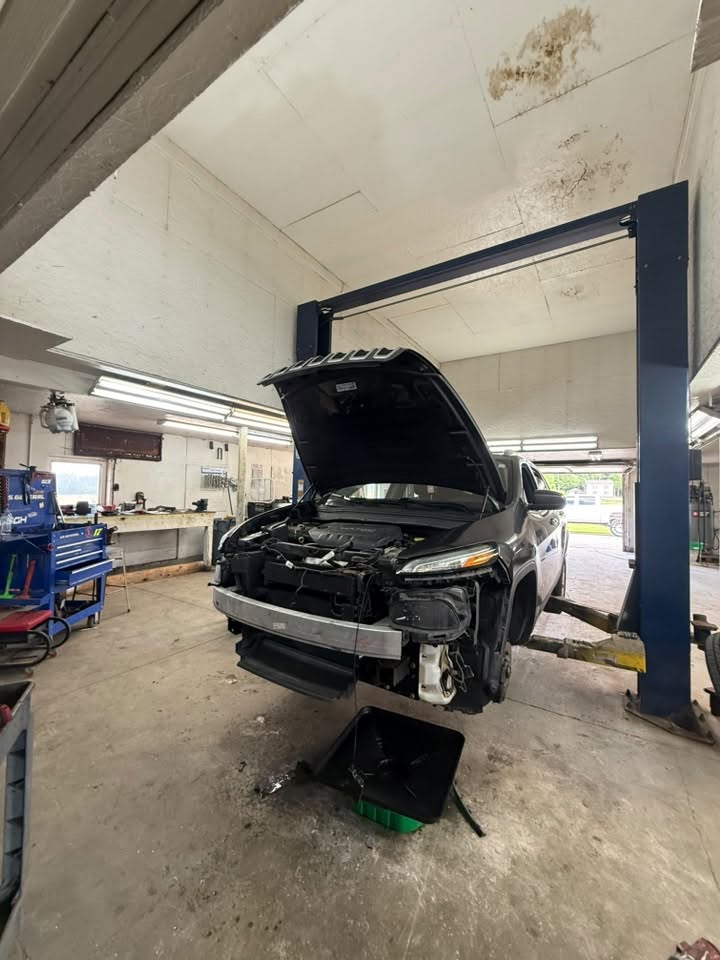 Jeep Cherokee on the lift at Javens AutoWorks with the front end apart for repair